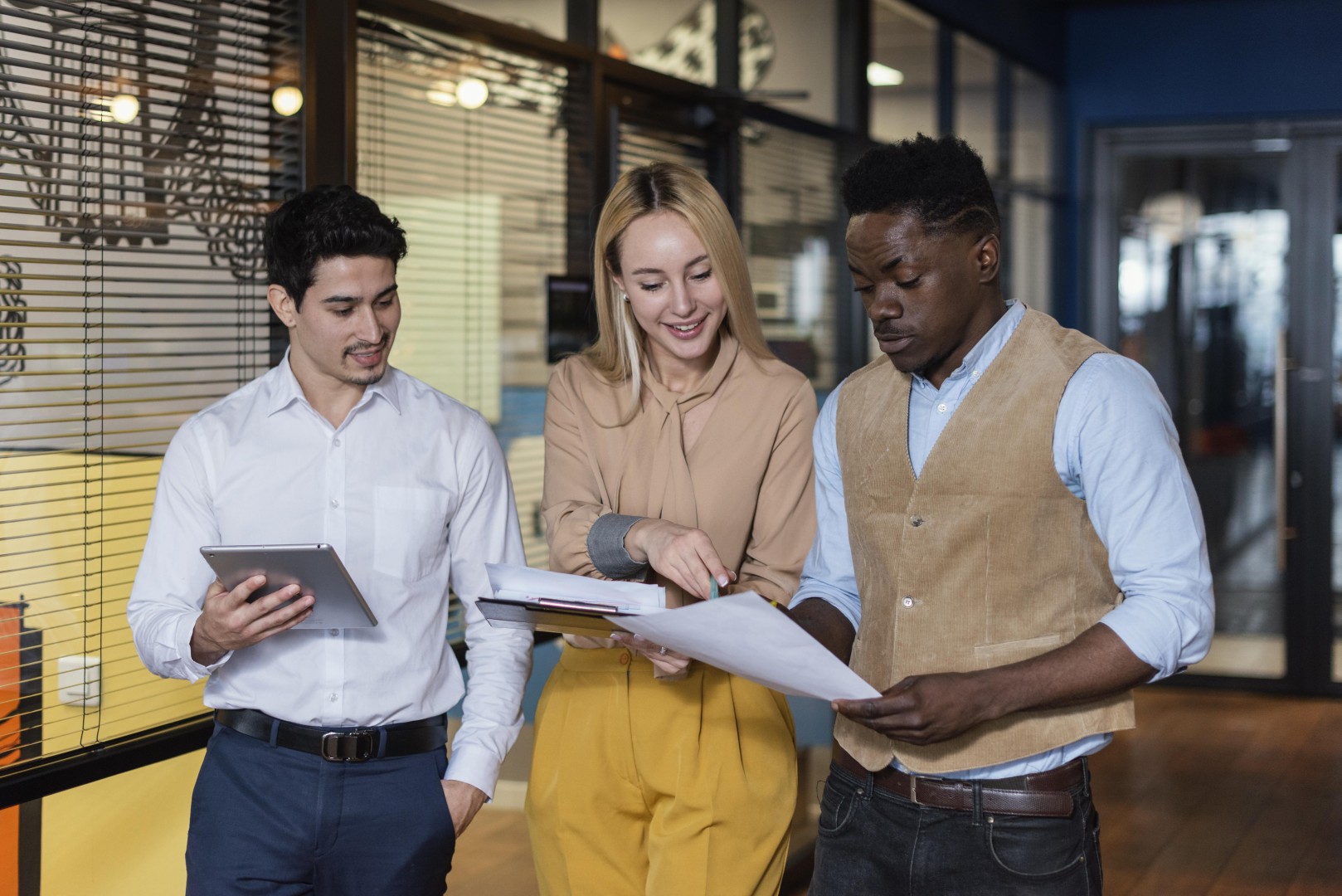 Sobre a Tropika 15 colegas de trabalho sorridentes olhando para documentos juntos Grande