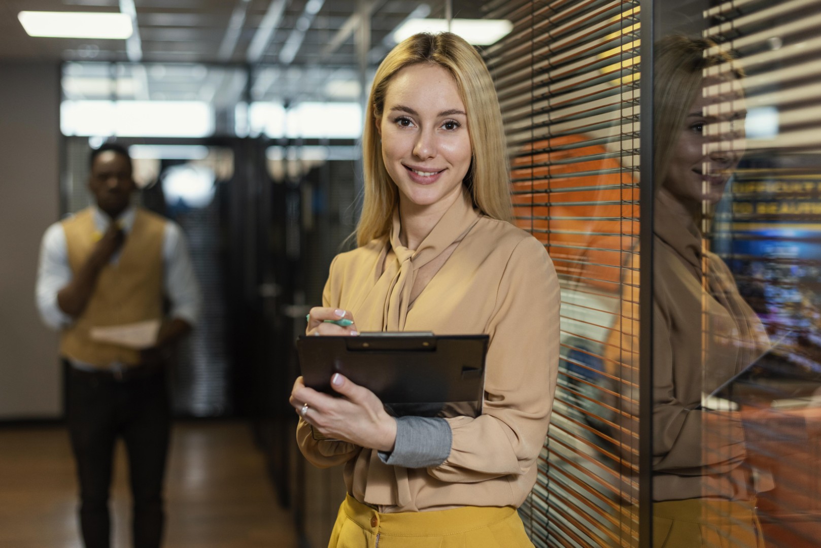 Sobre a Tropika 6 mulher sorridente segurando uma prancheta no local de trabalho Grande